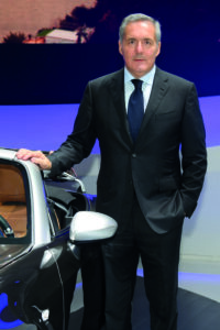 Alfredo Altavilla accanto a un&rsquo;auto durante una presentazione nel settore automotive.