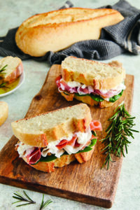 Panini farciti con salumi, formaggio e verdure preparati con filone di grano duro.