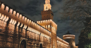 Milano, tra bellezza e bruttezza Castello Sforzesco di Milano illuminato di notte, con la Torre del Filarete e le mura in mattoni.
