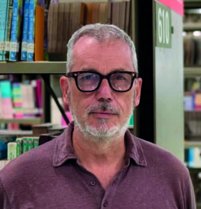Ritratto di Giancarlo Loquenzi in una biblioteca.