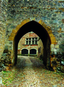 Arco medievale in pietra lungo una strada acciottolata nel centro storico di Perugia.