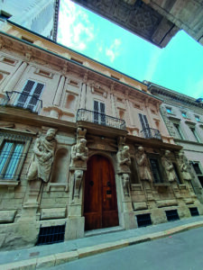 Facciata di Palazzo Leoni-Calchi a Milano, decorata con statue e balconi in ferro battuto.