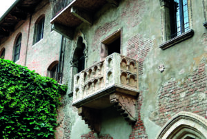 Balcone della Casa di Giulietta a Verona, sulla facciata storica in mattoni ricoperta in parte da edera.