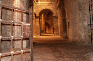 Interni della Rocca Paolina a Perugia, con passaggi in mattoni, archi medievali e antiche strutture sotterranee.